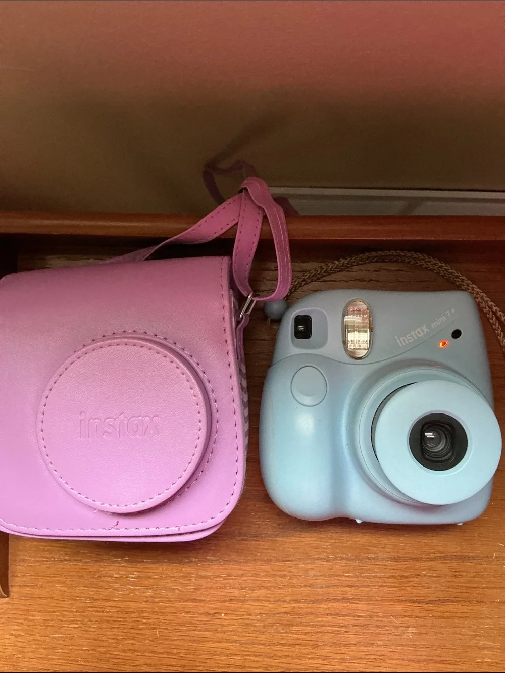 Instax Mini instant camera in light blue with pink carrying case